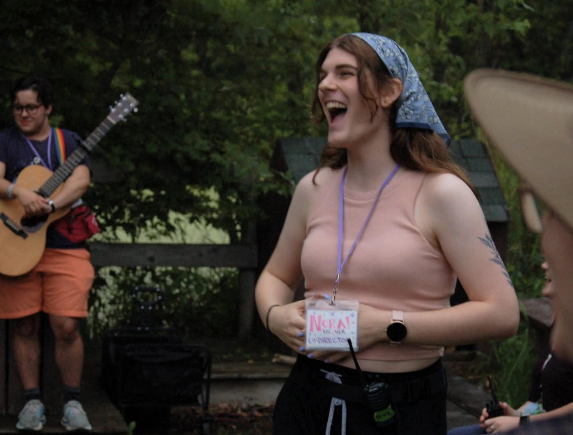 Youth & Young Adult Programming Young adults paddle canoes on a pond. Trees are visible in the distance.